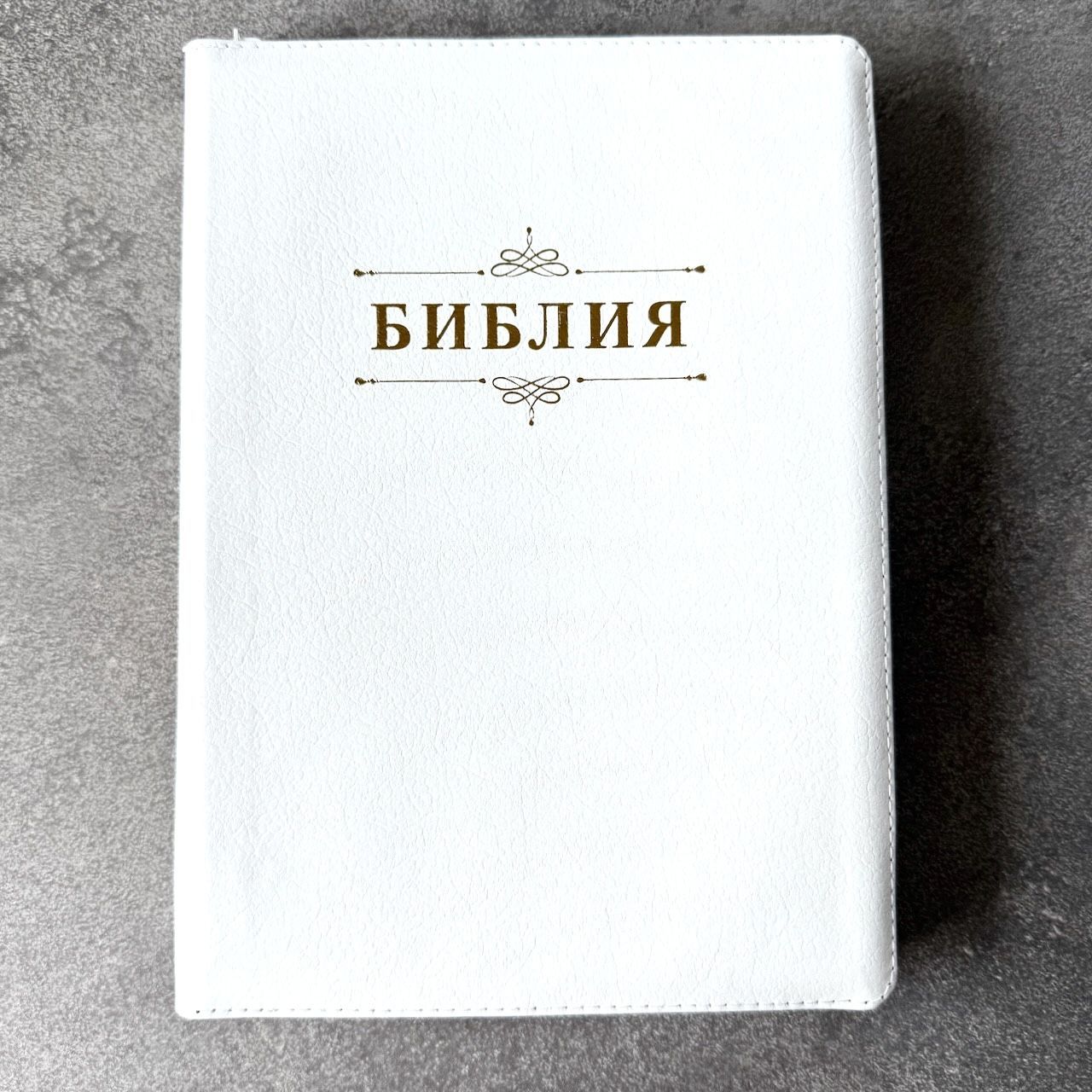 Дисконт. Бело-желтая полоска чуть выше центра спереди и сзади. Библия 076zti код 25076-16, дизайн "слово Библия", кожаный переплет на молнии с индексами, цвет белый пятнистый, размер 170x243 мм