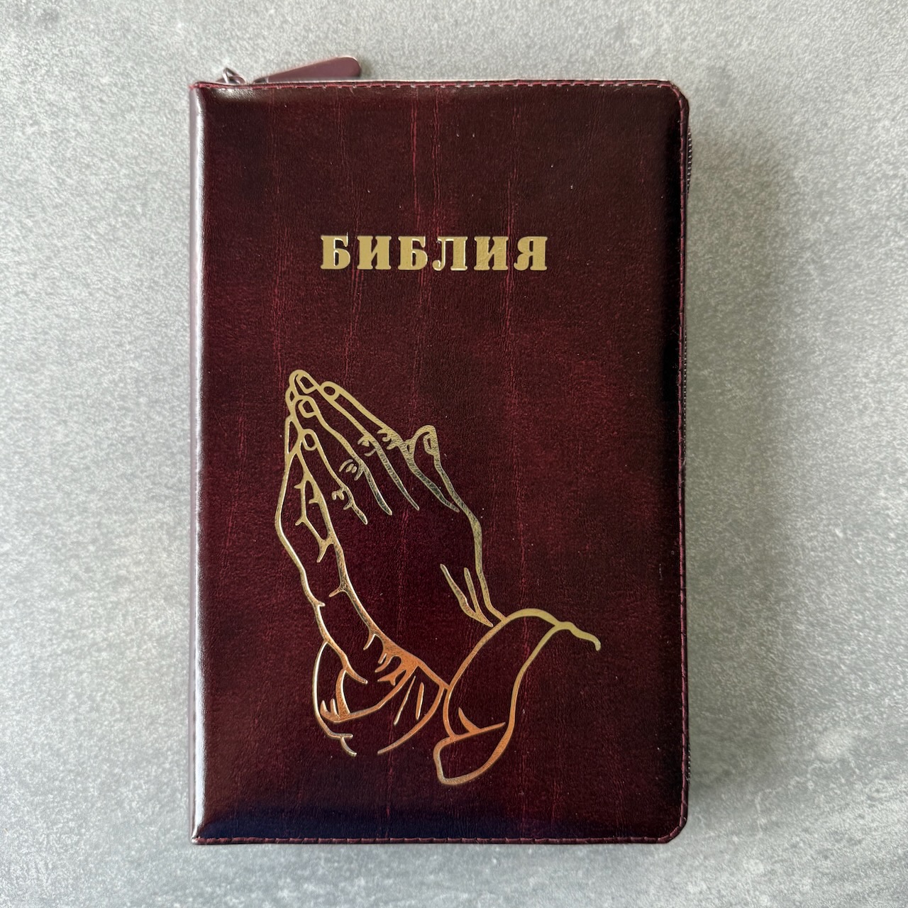 Библия 055z код 25055-26 дизайн "золотые руки молящегося", кожаный переплет на молнии, цвет коричневый с оттенком бордо с прожилками, средний формат, 143*220 мм