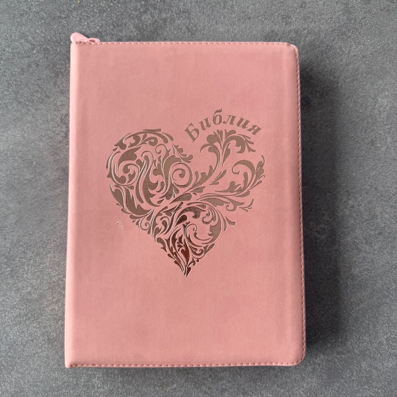 Дисконт №2 на лицевой обложке бело-серая точка слева по центру. Библия 076zti код 25076-40, дизайн "розово-золотое сердце", переплет из эко кожи на молнии с индексами,  цвет розовый, размер 170x240 мм