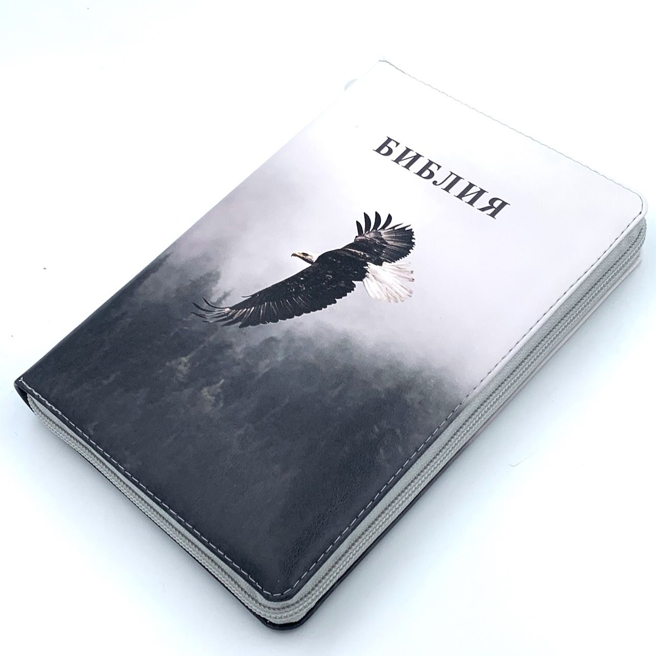 Дисконт Серая черточка с задней стороны обложки, по центру. Библия 055zti код 25055-66  цветная печать "Орел", переплет из искусственной кожи на молнии с индексами, формат 143*220 мм