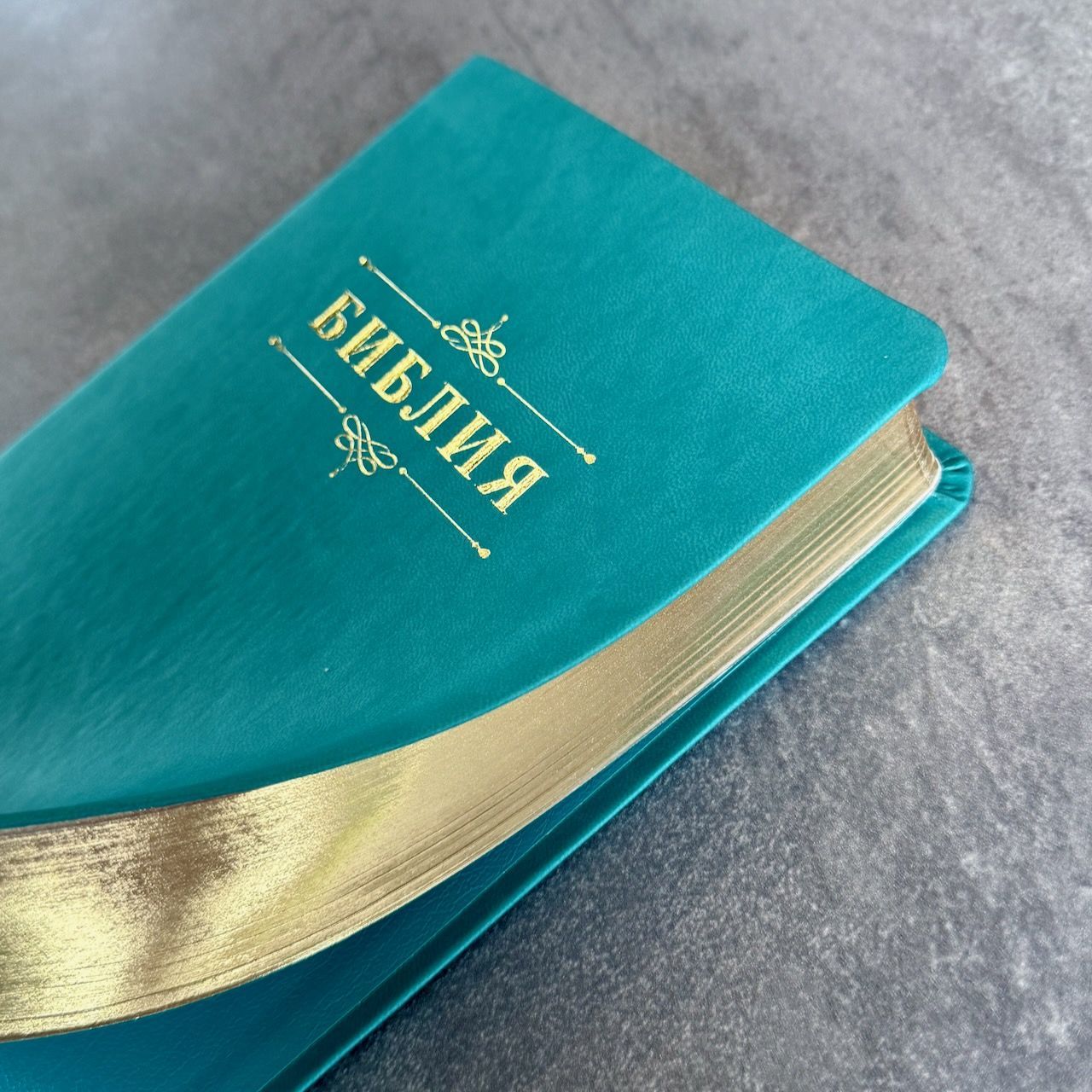  Дисконт №1 на лицевой обложке зацепка слева по центру, в верху по центру серая черточка. Библия 055 код 25055-60 дизайн "Библия с вензелем", переплет из эко кожи, цвет бирюзовый, средний формат, 143*220 мм