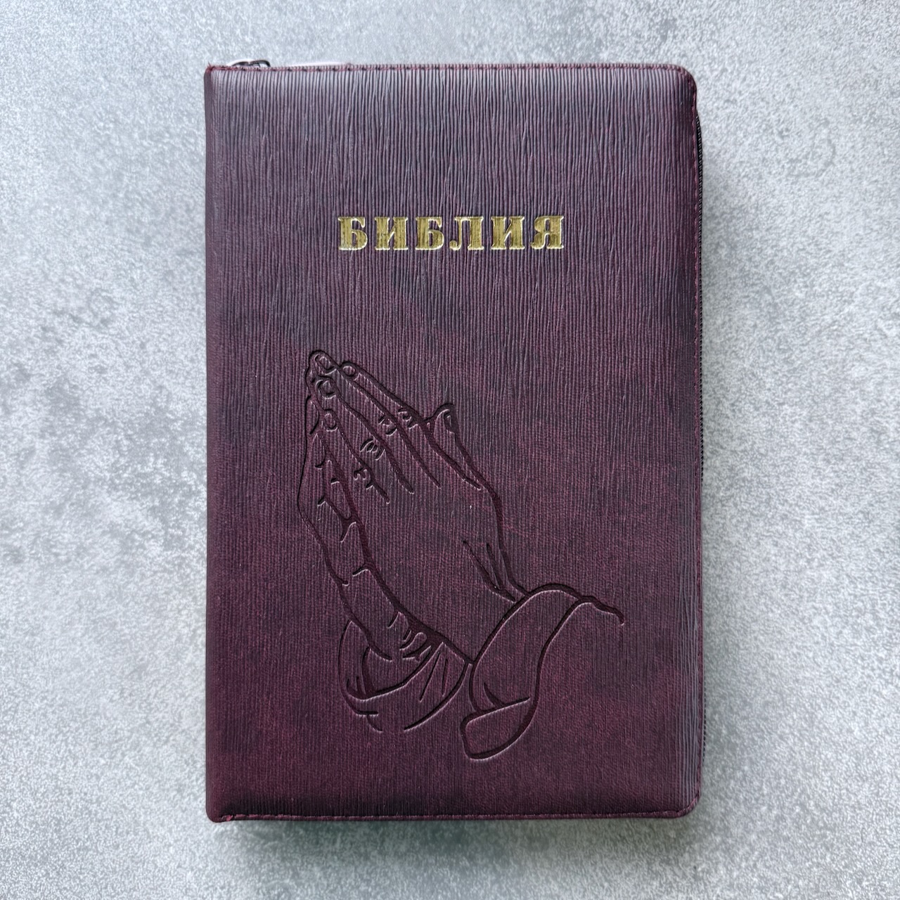 Библия 055z код 25055-54 термо штамп "руки молящегося", переплет из искусственной кожи на молнии, цвет темно-бордовый ребристый средний формат, 143*220 мм