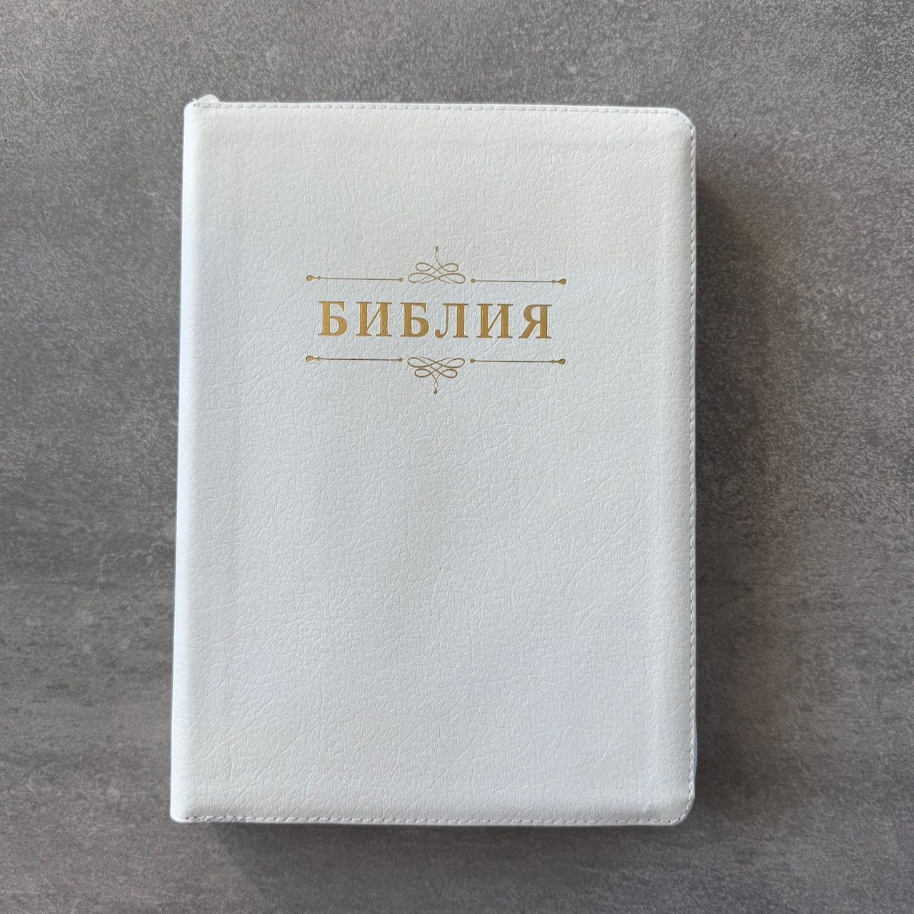 Дисконт. Бело-желтая полоска чуть выше центра спереди и сзади. Библия 076zti код 25076-16, дизайн "слово Библия", кожаный переплет на молнии с индексами, цвет белый пятнистый, размер 170x243 мм