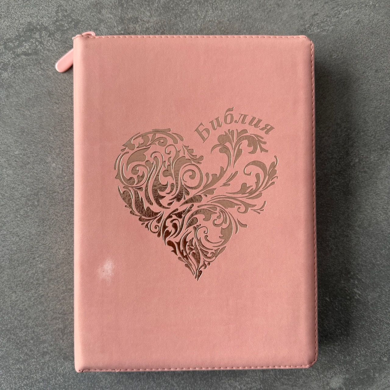 Дисконт №1. Белое пятнышко слева по центру на лицевой обложке. Библия 076z код 25076-45, дизайн "розово-золотое сердце", переплет из эко кожи на молнии,  цвет розово-золотой, размер 170x240 мм