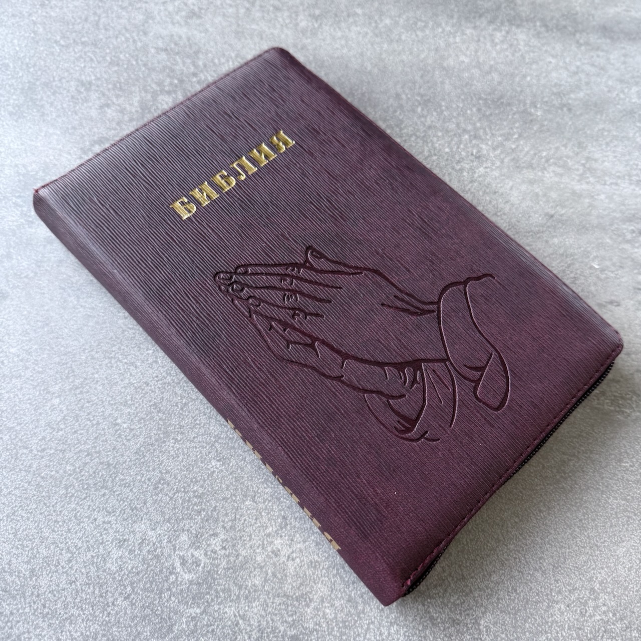 Библия 055z код 25055-54 термо штамп "руки молящегося", переплет из искусственной кожи на молнии, цвет темно-бордовый ребристый средний формат, 143*220 мм