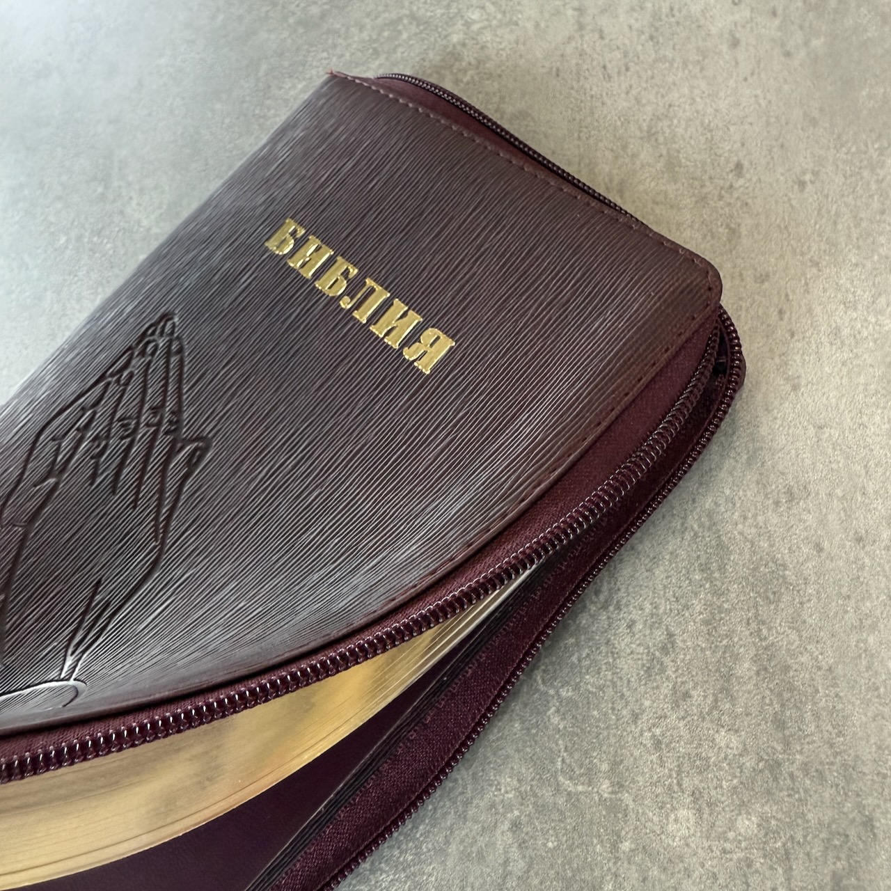 Библия 055z код 25055-54 термо штамп "руки молящегося", переплет из искусственной кожи на молнии, цвет темно-бордовый ребристый средний формат, 143*220 мм