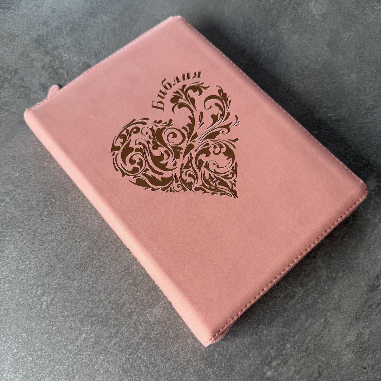 Дисконт №2 на лицевой обложке бело-серая точка слева по центру. Библия 076zti код 25076-40, дизайн "розово-золотое сердце", переплет из эко кожи на молнии с индексами,  цвет розовый, размер 170x240 мм