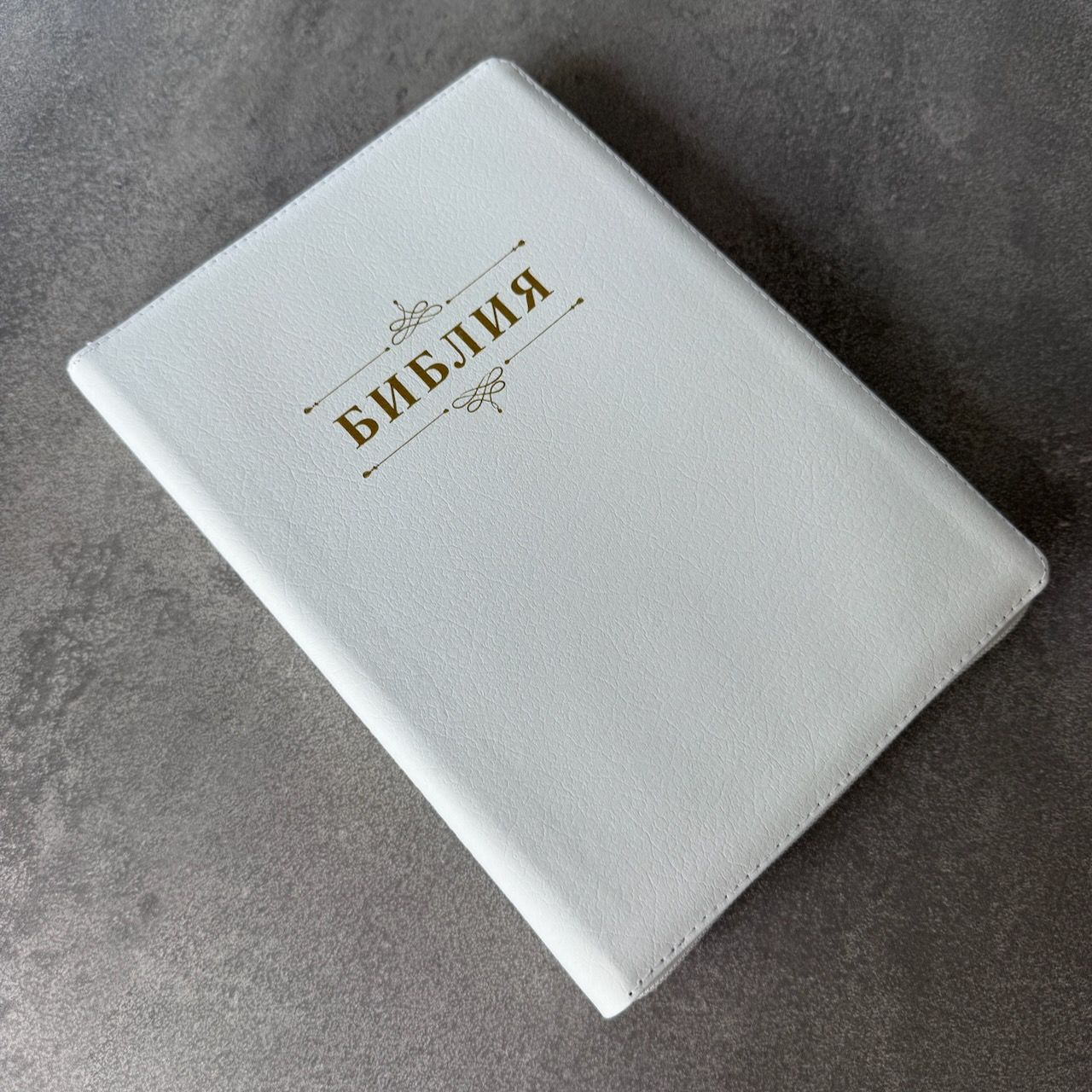 Дисконт. Бело-желтая полоска чуть выше центра спереди и сзади. Библия 076zti код 25076-16, дизайн "слово Библия", кожаный переплет на молнии с индексами, цвет белый пятнистый, размер 170x243 мм