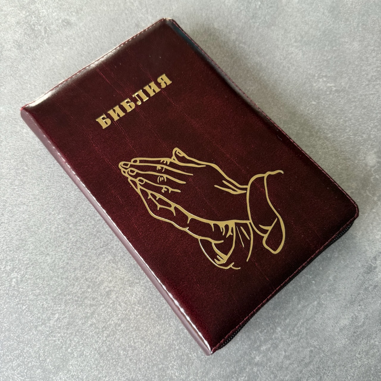Библия 055z код 25055-26 дизайн "золотые руки молящегося", кожаный переплет на молнии, цвет коричневый с оттенком бордо с прожилками, средний формат, 143*220 мм